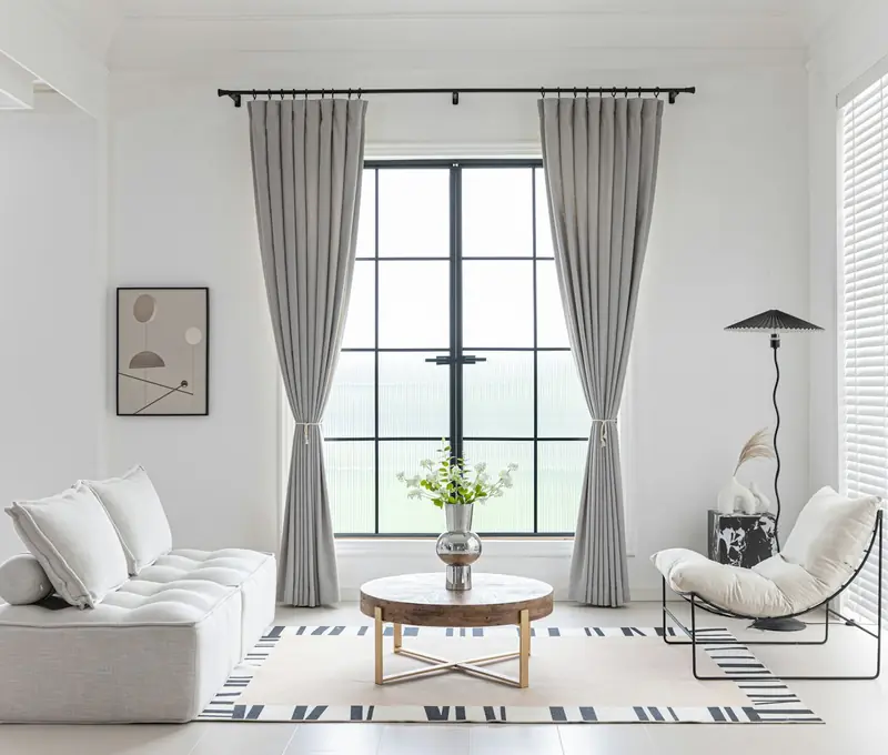 Sala clara con cortinas grises frente a un gran ventanal
